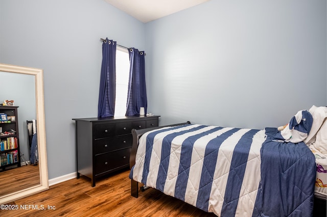 bedroom with baseboards and wood finished floors