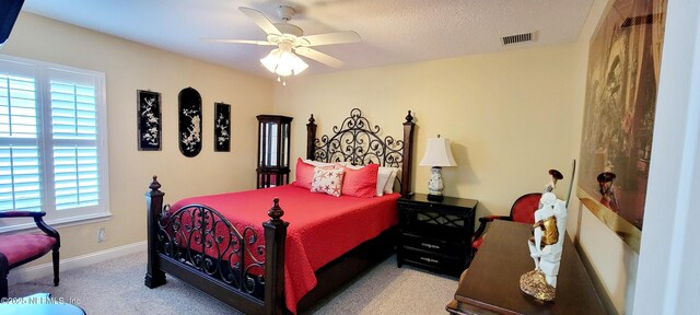 bedroom featuring a textured ceiling, carpet floors, a ceiling fan, visible vents, and baseboards