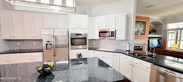 kitchen with stainless steel appliances, a sink, ornamental molding, and tasteful backsplash