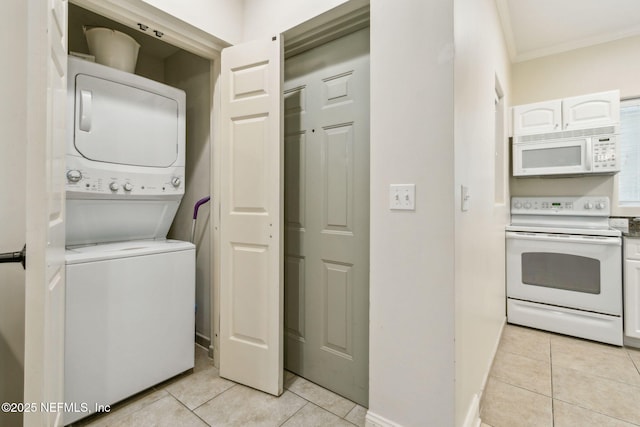 laundry area with laundry area, light tile patterned floors, crown molding, and stacked washer and clothes dryer