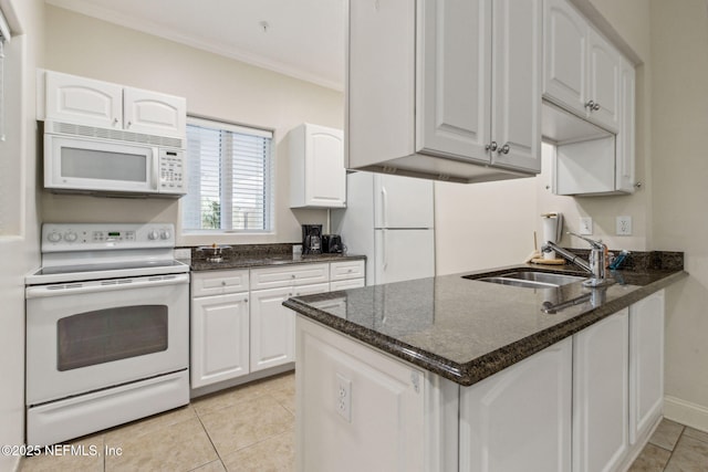 kitchen with white appliances, a sink, white cabinets, dark stone countertops, and crown molding