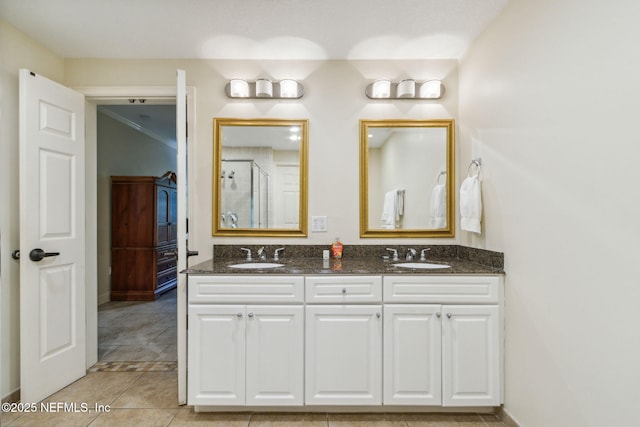 bathroom with double vanity, a stall shower, a sink, and tile patterned floors