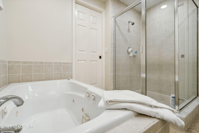 bathroom with a jetted tub and a stall shower