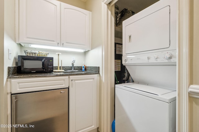 laundry area with laundry area, stacked washer / dryer, and a sink