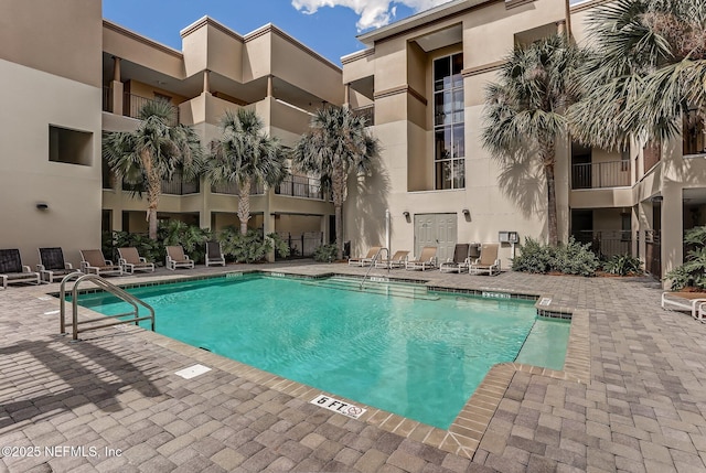 pool with a patio area and fence