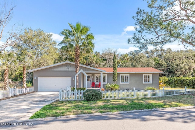 ranch-style home with a garage, a fenced front yard, concrete driveway, and stucco siding