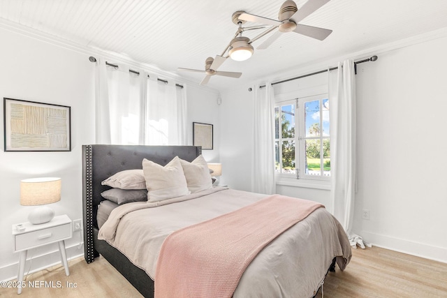 bedroom featuring crown molding, light wood finished floors, a ceiling fan, and baseboards