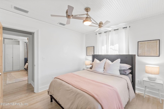 bedroom featuring light wood-type flooring, visible vents, and crown molding