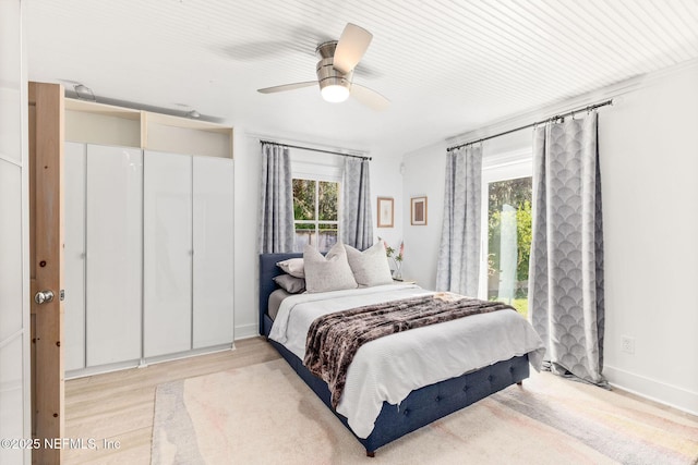 bedroom with light wood-type flooring, baseboards, and a ceiling fan