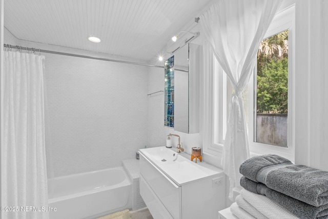 bathroom with a wealth of natural light, shower / bath combo with shower curtain, and vanity