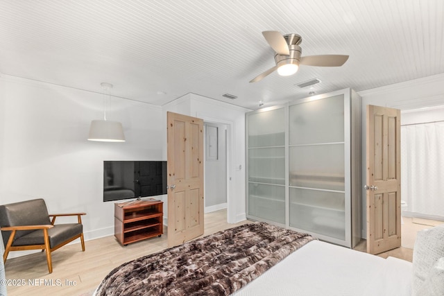 bedroom featuring a closet, visible vents, light wood-style flooring, and baseboards