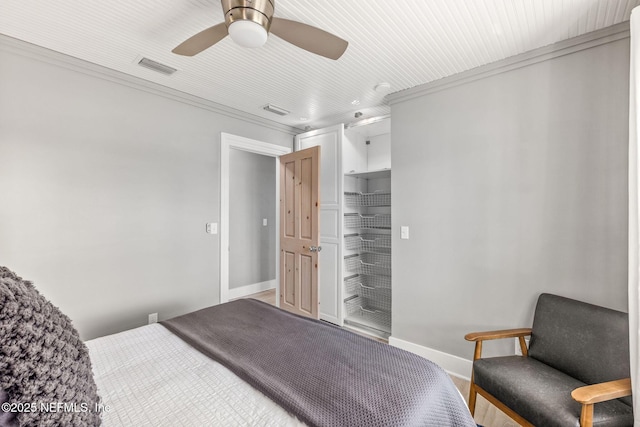 bedroom with ceiling fan, ornamental molding, visible vents, and baseboards