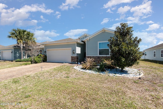 view of front of property featuring driveway, stone siding, an attached garage, and a front yard