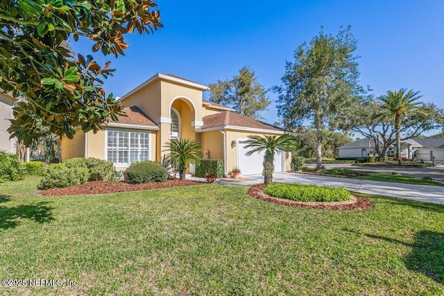 mediterranean / spanish house with stucco siding, a front lawn, concrete driveway, and an attached garage