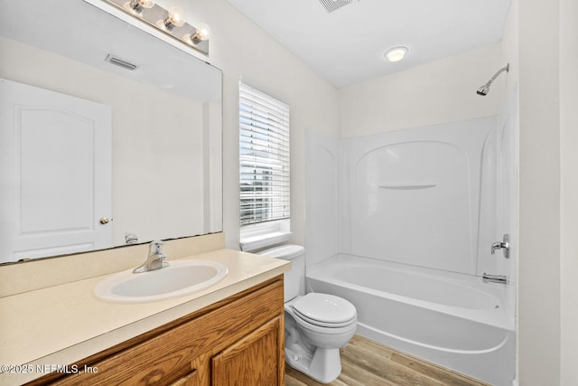 full bath featuring visible vents, toilet, wood finished floors,  shower combination, and vanity