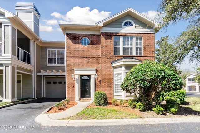 view of front of property featuring driveway, an attached garage, and brick siding