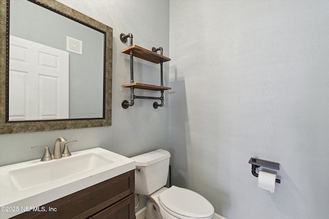 half bathroom with visible vents, vanity, and toilet