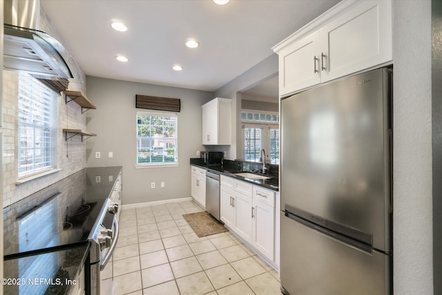 kitchen featuring white cabinets, stainless steel appliances, a sink, and light tile patterned flooring