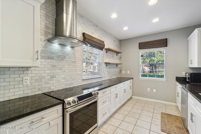 kitchen with stainless steel appliances, backsplash, light tile patterned flooring, white cabinetry, and wall chimney exhaust hood