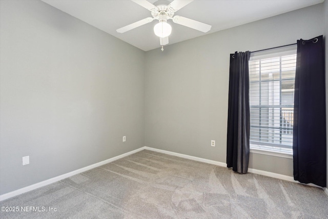 carpeted empty room featuring ceiling fan and baseboards