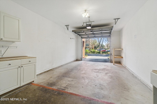 garage with baseboards and a garage door opener