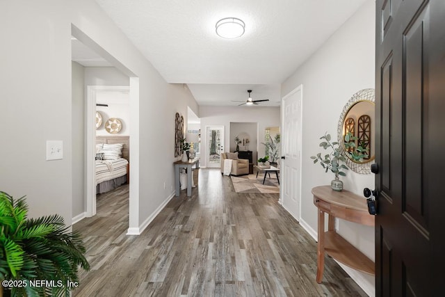 entryway featuring ceiling fan, baseboards, and wood finished floors