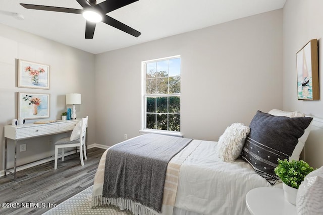 bedroom featuring wood finished floors, a ceiling fan, and baseboards