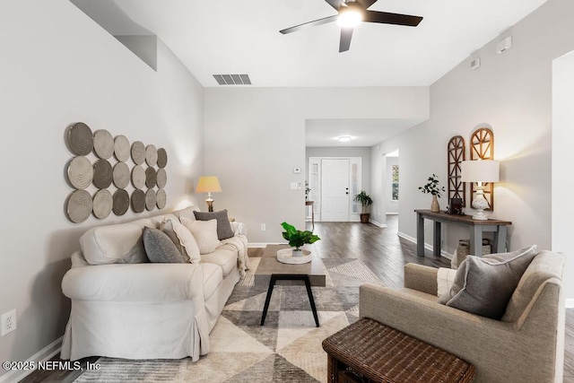 living area with a ceiling fan, baseboards, visible vents, and wood finished floors