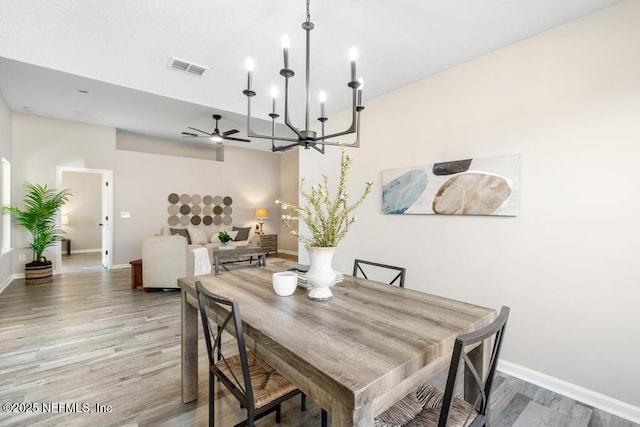 dining space featuring light wood-style flooring, visible vents, and baseboards