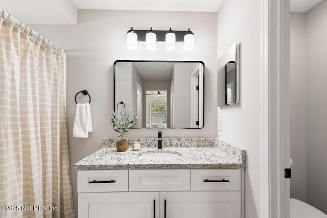 bathroom with toilet, ceiling fan, and vanity