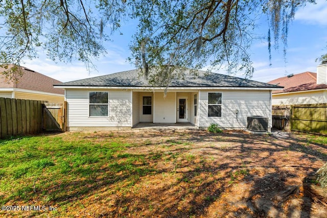 rear view of house featuring a yard, a patio, central AC unit, a gate, and a fenced backyard