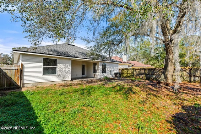 back of property with a patio area, a fenced backyard, and a lawn