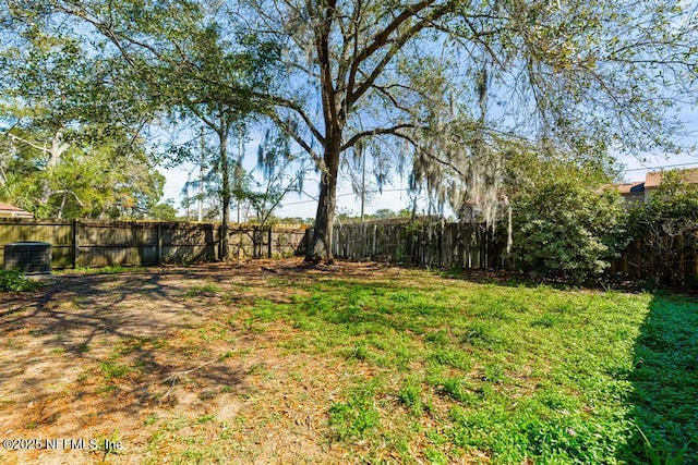 view of yard featuring a fenced backyard and central AC