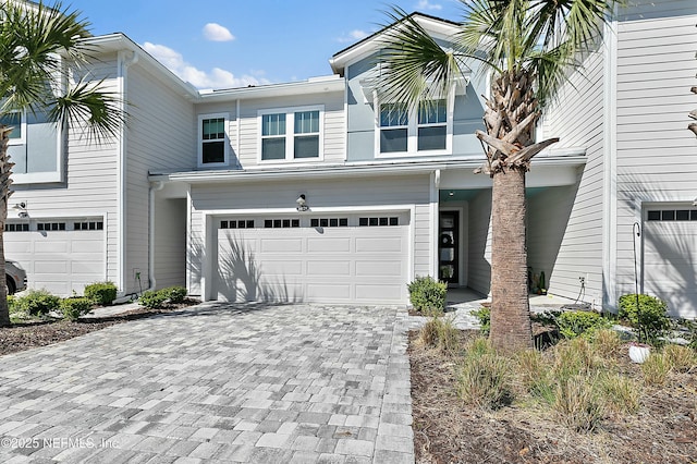 townhome / multi-family property featuring decorative driveway and an attached garage