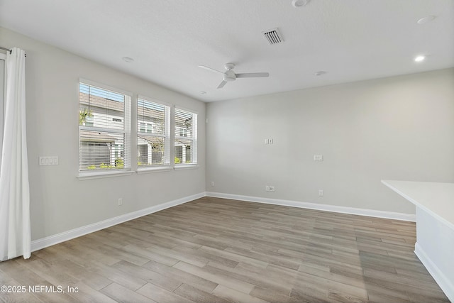 spare room with light wood-type flooring, visible vents, a ceiling fan, recessed lighting, and baseboards