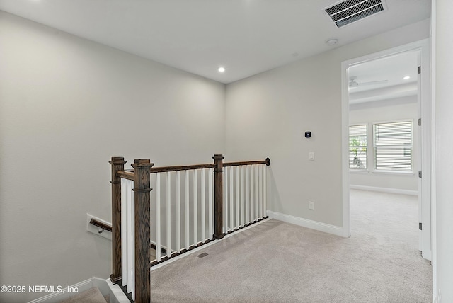 corridor featuring visible vents, baseboards, carpet, an upstairs landing, and recessed lighting