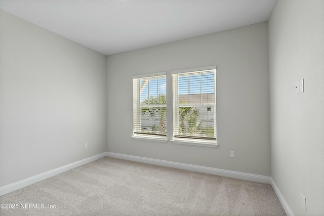 unfurnished room with baseboards and light carpet