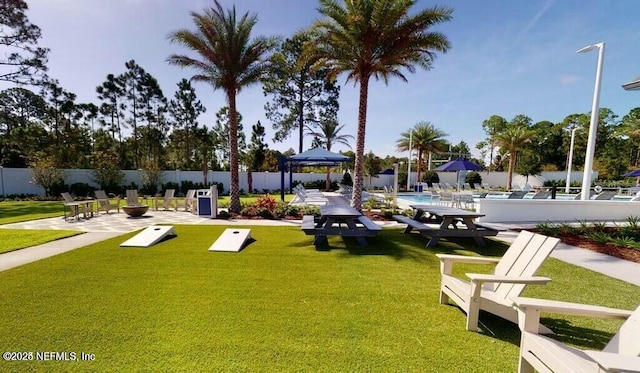 view of community featuring a pool, a patio area, a yard, and fence