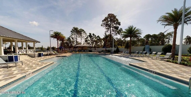 community pool with a gazebo, a patio, and fence