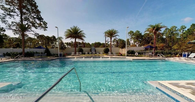 community pool featuring a patio area and fence