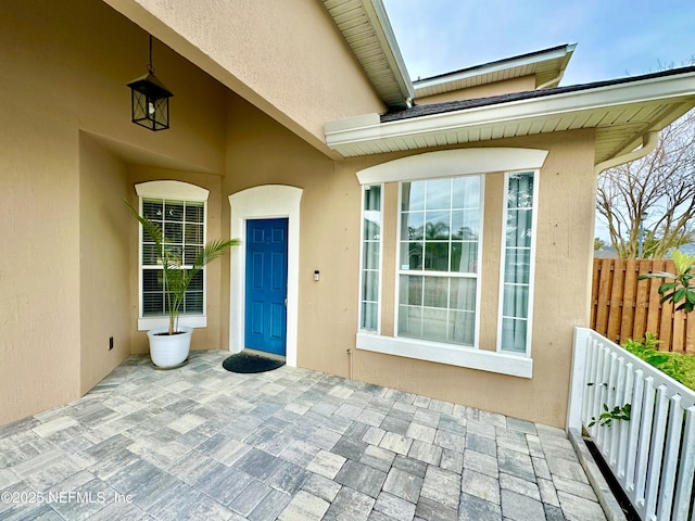 doorway to property featuring stucco siding