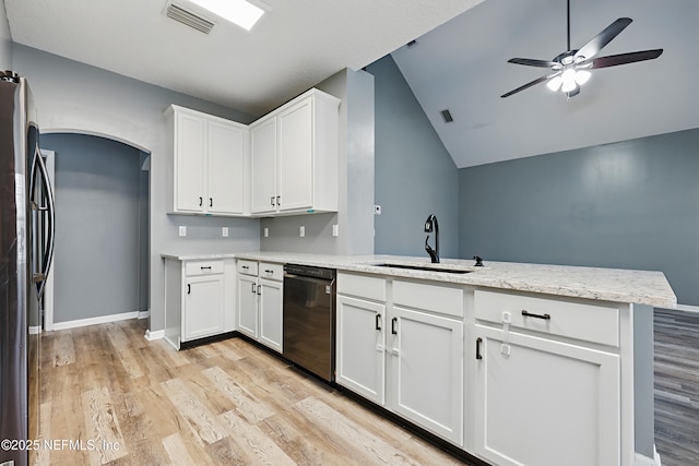 kitchen featuring black dishwasher, visible vents, freestanding refrigerator, a peninsula, and a sink