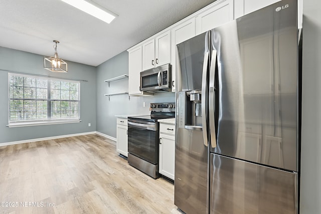 kitchen featuring light wood finished floors, stainless steel appliances, light countertops, white cabinetry, and open shelves