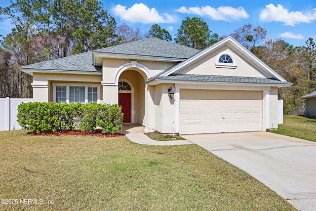 view of front of home with an attached garage, fence, concrete driveway, stucco siding, and a front lawn