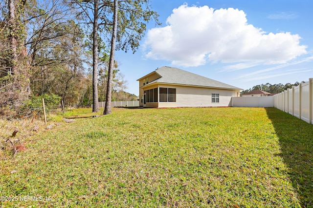 view of yard featuring a sunroom and a fenced backyard