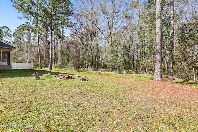 view of yard with fence and a forest view