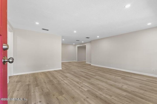 empty room with recessed lighting, baseboards, and wood finished floors