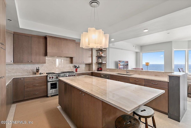 kitchen featuring tasteful backsplash, a center island, a peninsula, high end stainless steel range, and a sink