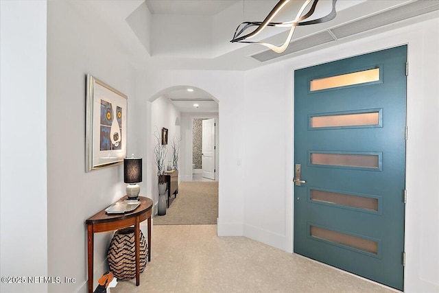 foyer with baseboards and arched walkways