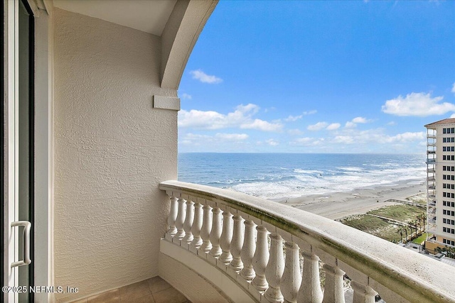 balcony with a water view and a beach view